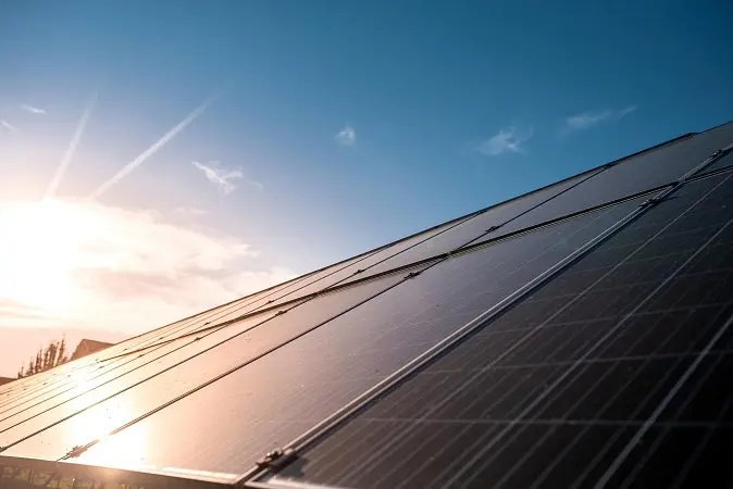 Fotovoltaické panely na střeše při slunečním svitu.