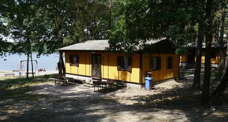 Žluté chaty v lese u jezera - typické pro kempování.