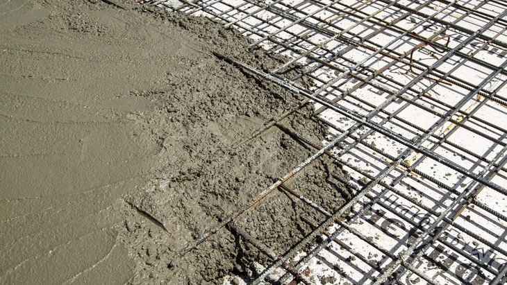 Čerstvý beton nalitý na ocelovou výztuž v armatuře.