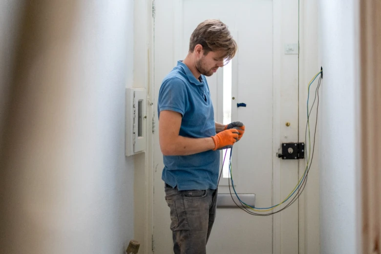 Elektrikář pracuje na instalaci drátů v domácnosti.