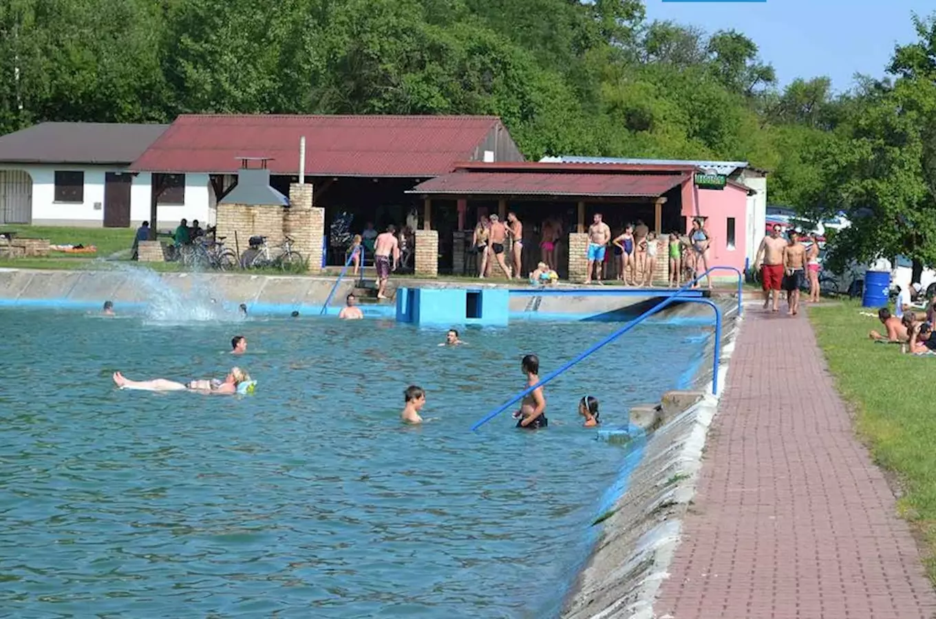 Venkovní bazén ve Všejanech s lidmi v koupališti.