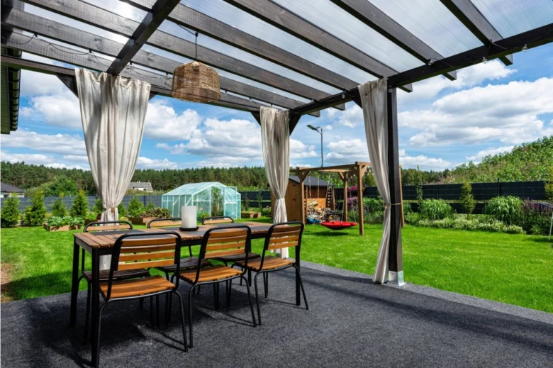 Pergola s plastovou střešní krytinou na zahradě.