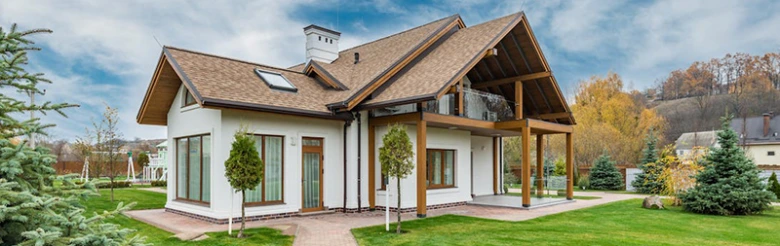 Moderní dům s typickou sedlovou střechou v zelené zahradě.