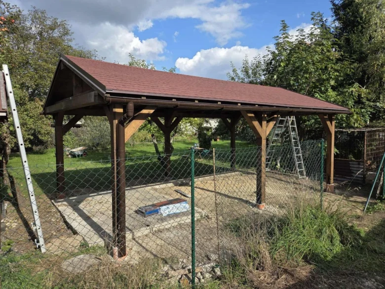 Montáž dřevěné pergoly s viditelnými sloupy a konstrukcí.