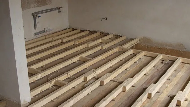 Dřevěné trámy a latě pro rekonstrukci dřevěného stropu v interiéru.