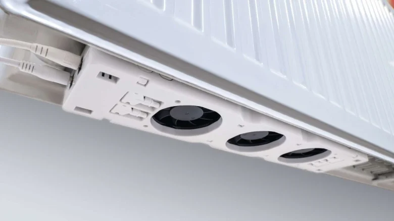 Bílý radiátor s nainstalovanými ventilátory na boční straně.