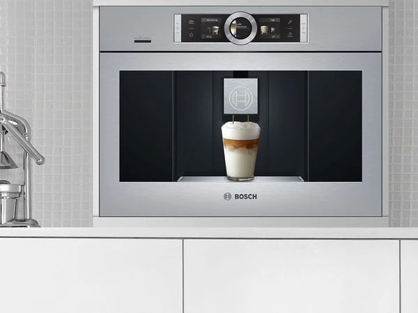 Vestavěná kávová příprava značky Bosch v kuchyňské skříni.