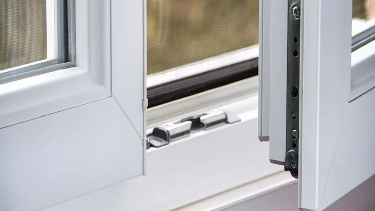 Detailní pohled na vnitřní zámek plastového okna při otevření.