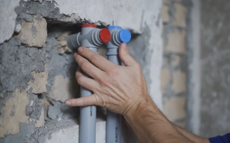 Ruční instalace plastových vodovodních trubek do zdi