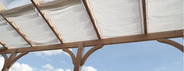 Dřevěná pergola s bílým plátnem pro zastínění terasy.
