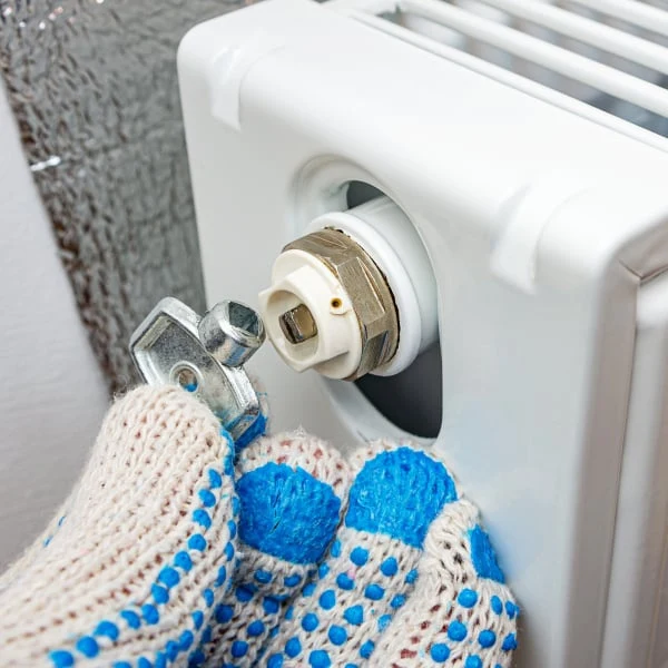 Ruční odšroutování ventilu na radiátoru pro odvzdušnění.