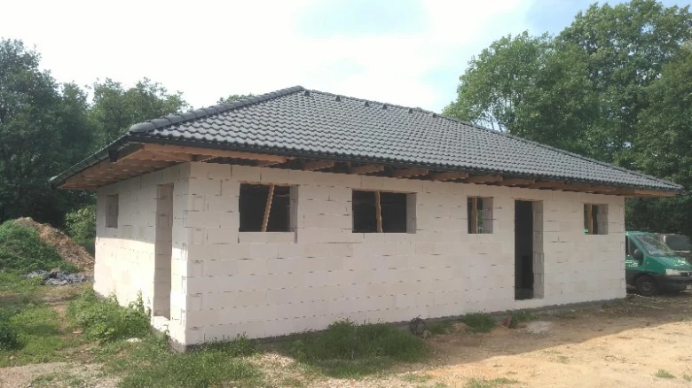 Nezhotovený zděný bungalov s taškami na střeše.