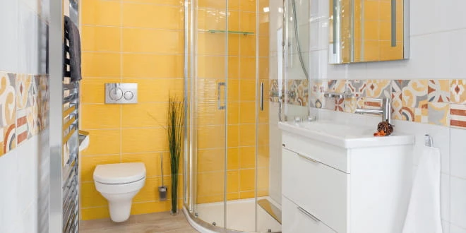 Moderní malá koupelna s žlutými dlaždicemi a bílou sanitou.