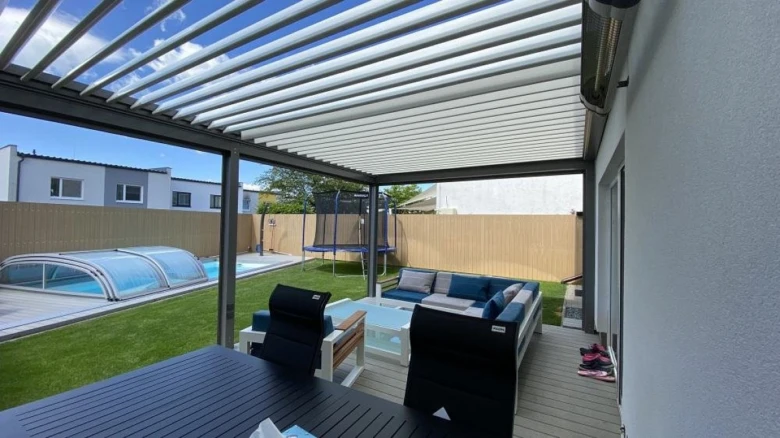 Moderní hliníková pergola nad zahradním posezením u bazénu.