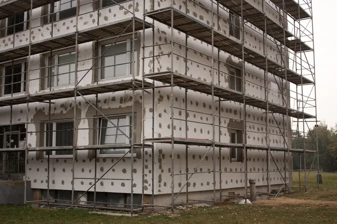 Budova s fasádou zateplenou panely a opatřená stavebním lešení.