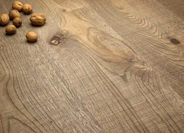 Dřevěná podlaha s vlašskými oříšky na povrchu.