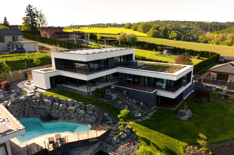 Moderní luxusní vila s bazénem na kopci v přírodě.