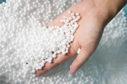 Ruka drží bílé expandovaný polystyrenové granule.