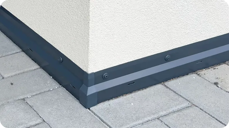Detail ukončení nopové folie na rohu budovy s tmavým obvodovým prvkem.