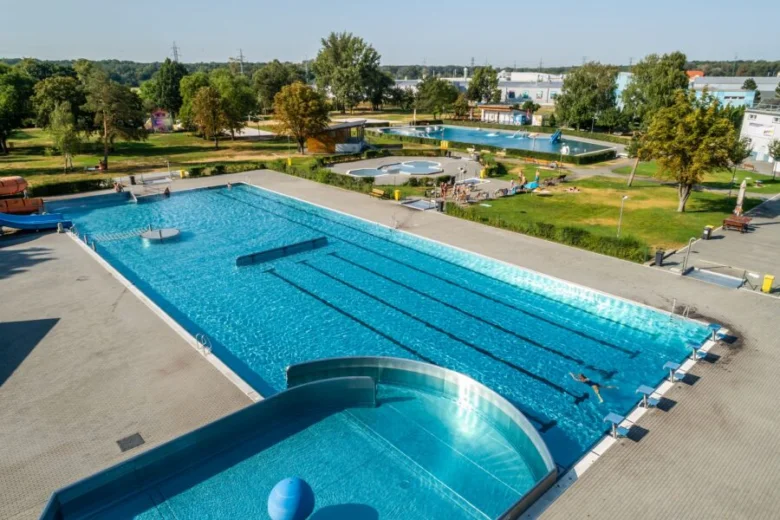 Velké venkovní bazénové komplex s okolním parkem v Hodoníně.