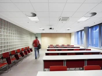 Interiér s kazetovým stropem v učebně nebo konferenčním sále.