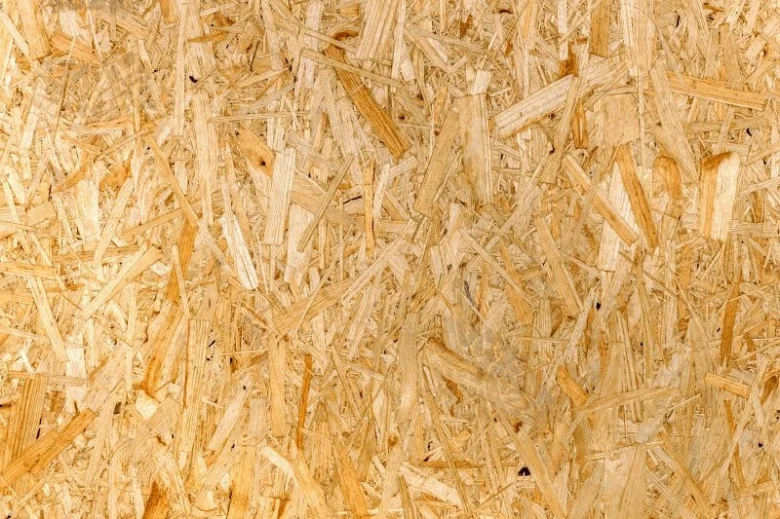 Detailní záběr na texturu desky z orientovaných dřevěných vláken.