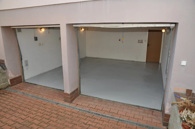 Dva otevřené garáže s novými nátěry podlah na beton.