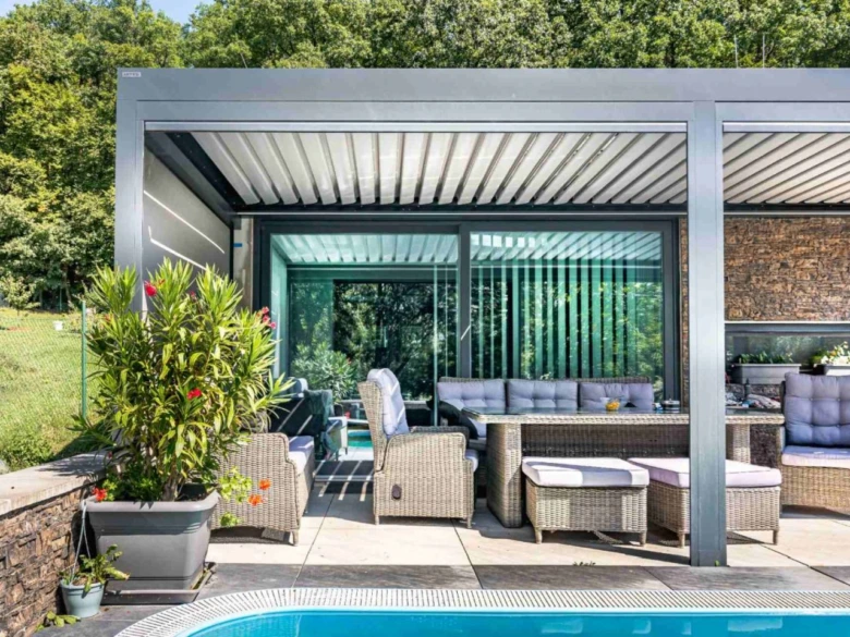 Moderní hliníková pergola s venkovním sedacím nábytkem u bazénu.
