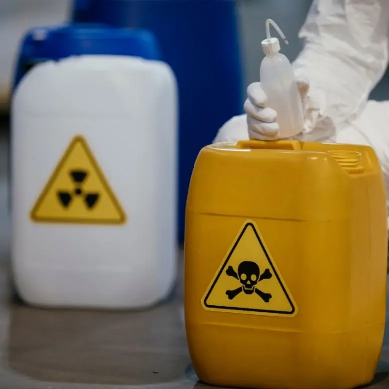 Žlutá nádoba s piktogramem smrti vedle bílého kontejneru s radiologickým symbolem.