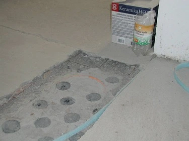 Příprava betonového potěru pro instalaci topných trubek.