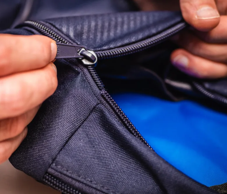 Hands opening zipper on bag