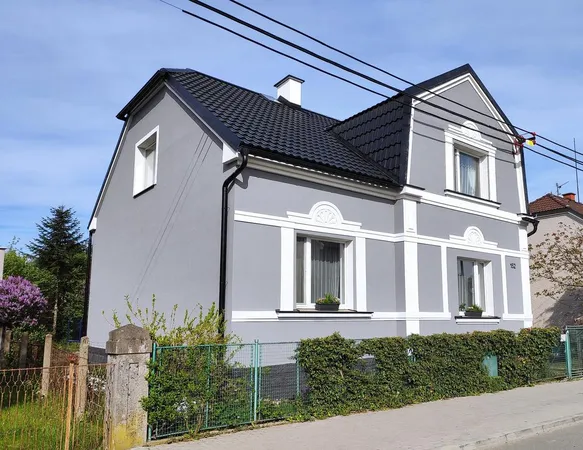 Modernizovaná fasáda domu s novou střechou a zateplením.