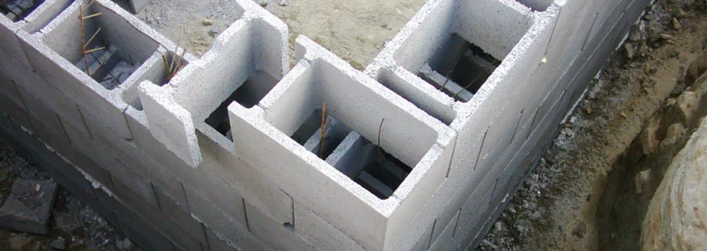 Část stavby z betonových bloků s výztuží v dutinách.