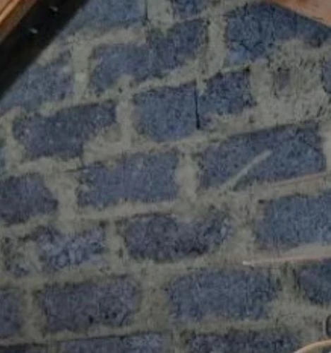 Modrá omíta na zdivu ze škvárobetonu s viditelnými spár.