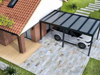 Bílý automobil pod moderním přístřeškem u domu s dlažbou.