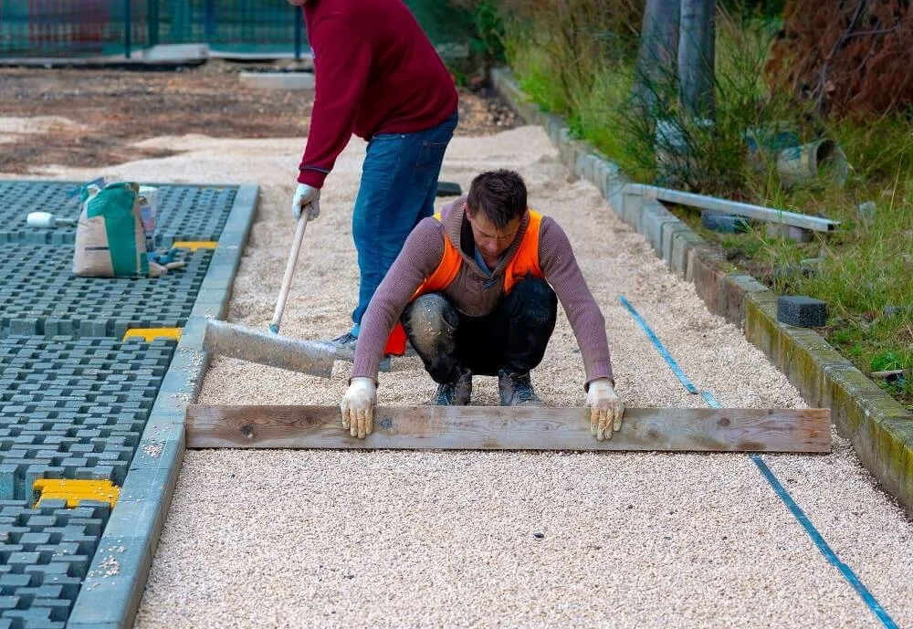 Workers laying permeable pavers