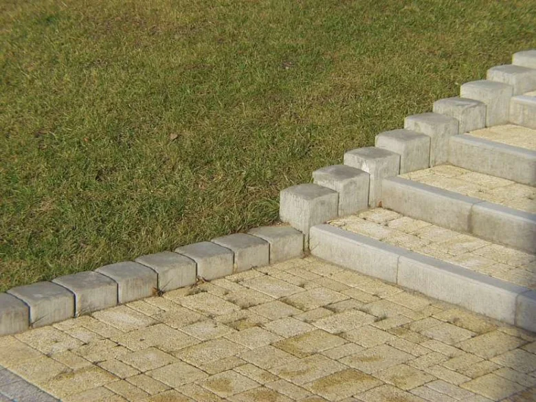 Základní schody ze zámkové dlažby s kamenným obrubníkem.