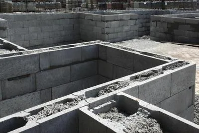 Základová stěna z betonových bloků s viditelnými prázdnými jádry.