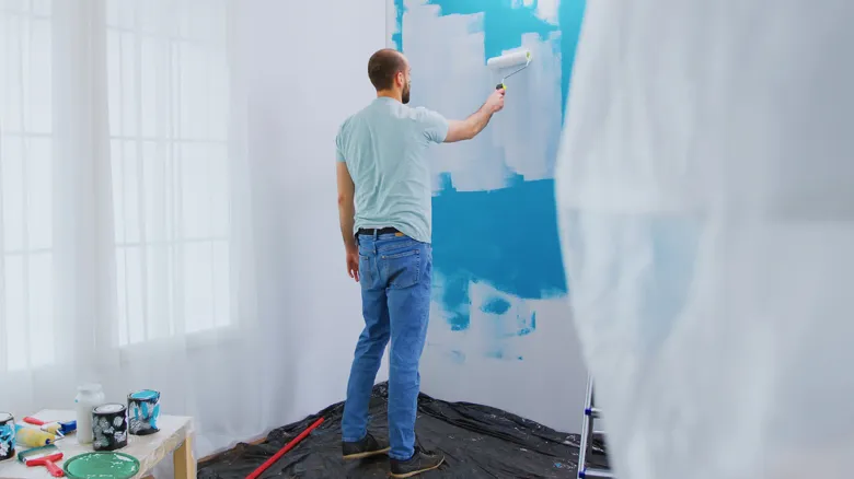 Man painting a wall blue