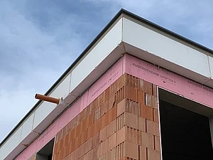 Detailní pohled na stavbu atiky s cihlami a izolační pěnou