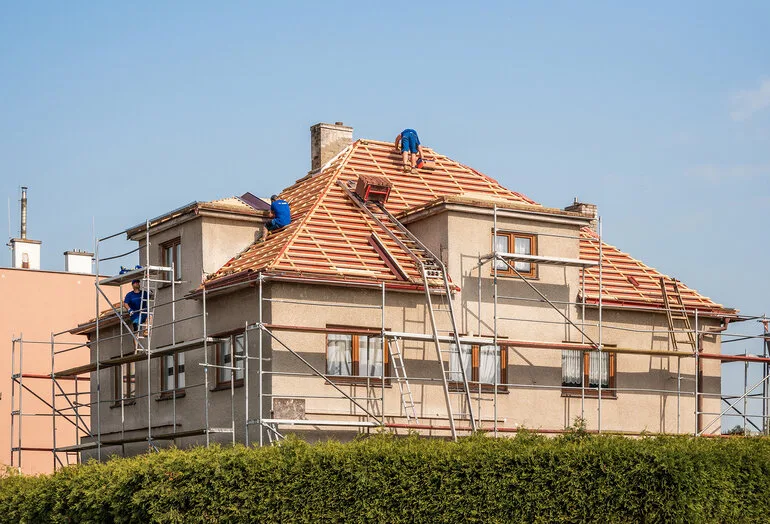 Práce na rekonstrukci střechy s instalací nových tašek.