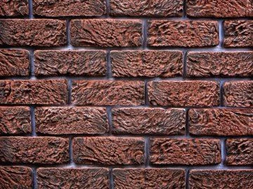 Detail červené cihlového obkladu na fasádu budovy.