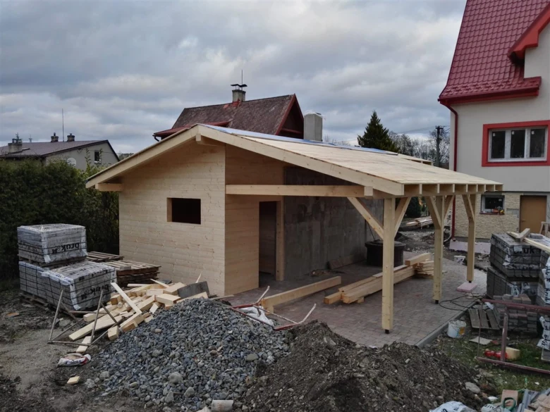 Stavba dřevěné kůlny na palivové dřevo s materiály kolem.