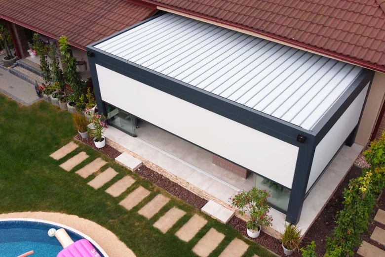 Bioklimatická pergola s výtažnými lamelami připojená k domu.