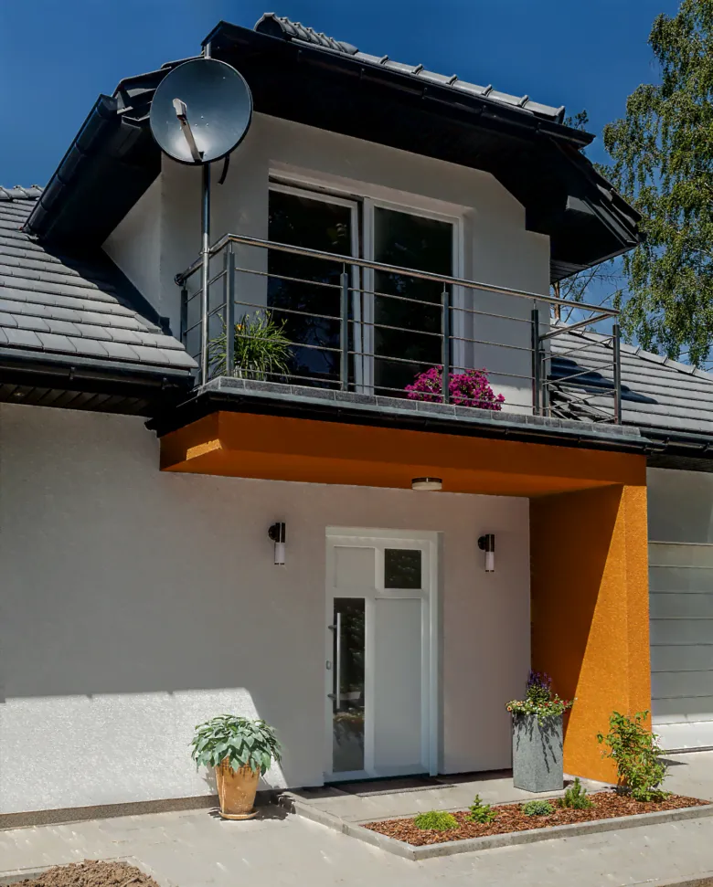 Moderní bílé vstupní dveře do domu pod lodžií.