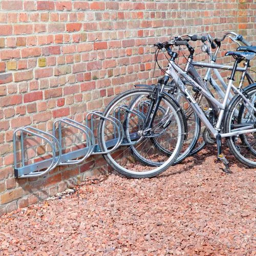 Stojan na kola připevněný ke zdi s několika bicykly.