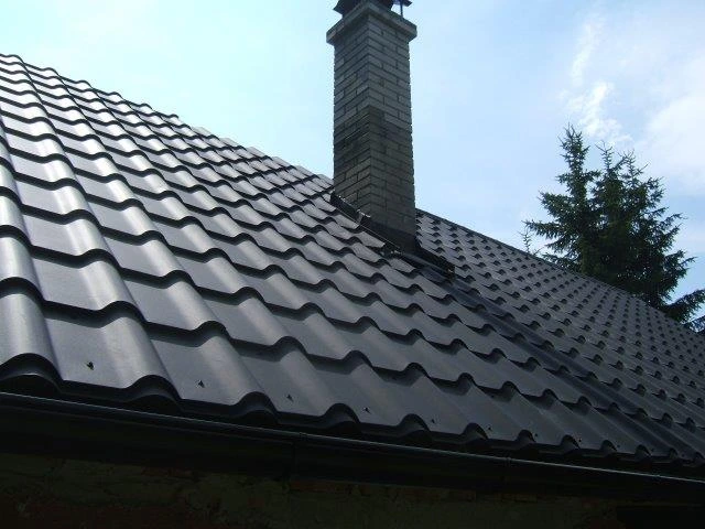 Plechová střešní krytina s vlnitými dlaždicemi na střechě domu.