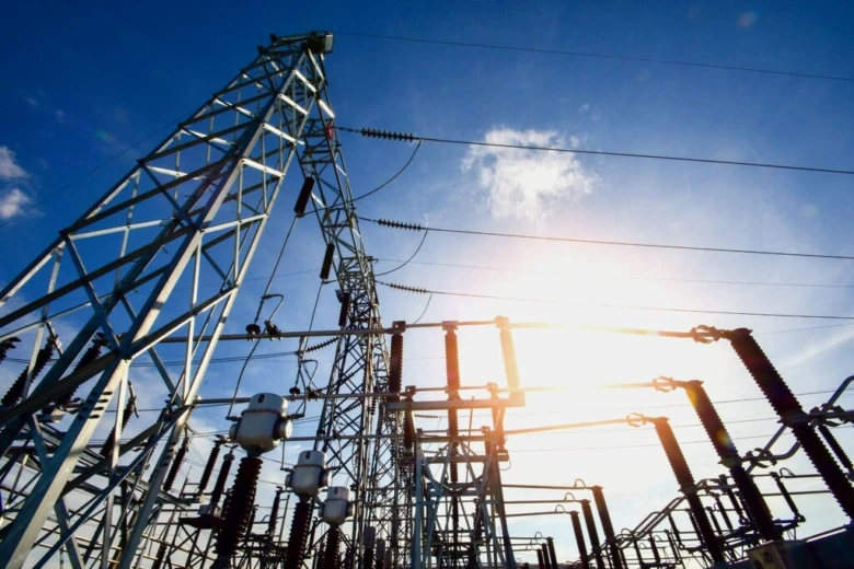 Elektrické vedení s vysokým napětím pod modrou oblohou.