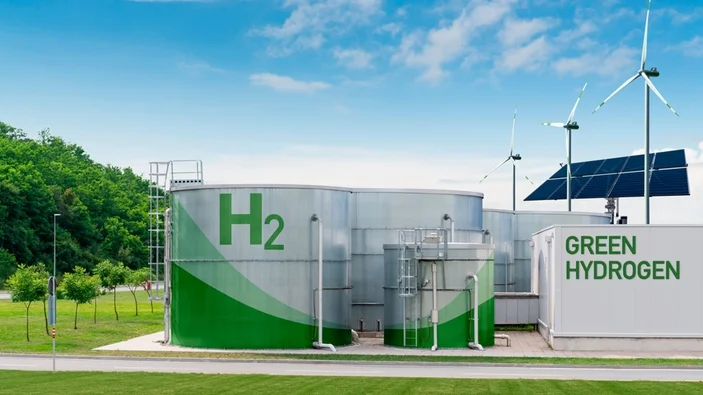 Moderní továrna na výrobu zeleného vodíku s větrnými turbínami.