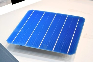 Modrá fotovoltaická solární buňka s viditelnými kontakty.